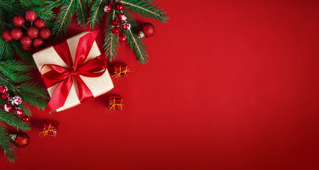 Merry Christmas holiday background. Red Christmas flat lay background with gift box, fir branches and holiday decorations.