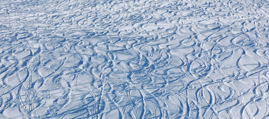 Powder snow with ski and snowboard tracks,winter background, Switzerland.