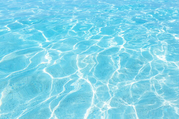 Abstract blue colored water with ripples on surface. Turquoise clear water with shining texture background. Top​ view​ of blue​ water.​