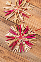Straw star on wooden background. Christmas tree decoration made of straw.