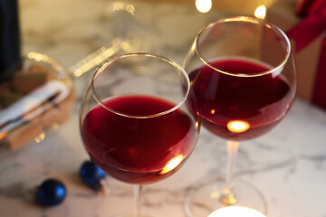 Glasses of red wine and Christmas decor on table, closeup