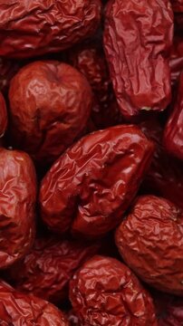 Pile of dried Chinese jujube fruit (red dates) rotating for background texure. Top view shot