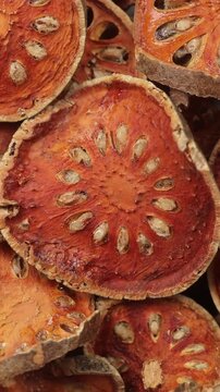 Pile of dried Bael fruit slices rotating for background texture. Top view shot