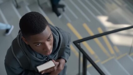 Young student ascending stairs in busy school hallway with determination - Powered by Adobe