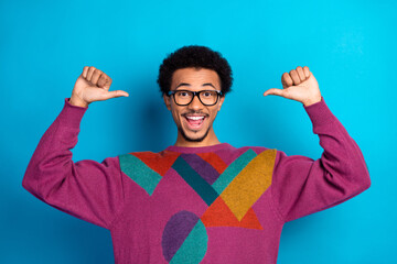 Energetic young man in colorful sweater gesturing with confidence against a bright background