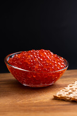 Red Salmon Roe (Ikura) in glass plate on Black Background
