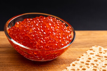 Red Salmon Roe (Ikura) in glass plate on Black Background