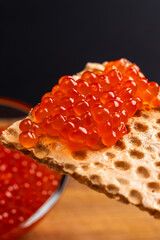 Red Salmon Roe (Ikura) in Plastic Container on Black Background