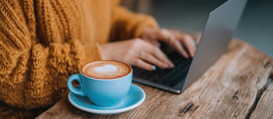Cozy autumn scene with a person working on a laptop and a cup of coffee.