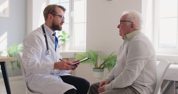 Male doctor in white coat shaking hands with senior man patient, beginning medical consultation, asks about condition or health concerns in clinic office. Gerontology, healthcare concept
