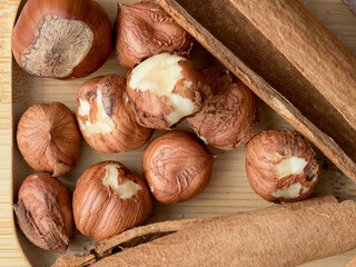 Hazelnuts, cinnamon, chocolate with nuts, background, Christmas wallpaper on a wooden countertop, close-up view, healthy unsaturated fats, spices, plant protein, fiber, vitamins and minerals