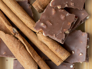 Hazelnuts, cinnamon, chocolate with nuts, background, Christmas wallpaper on a wooden countertop, close-up view, healthy unsaturated fats, spices, plant protein, fiber, vitamins and minerals