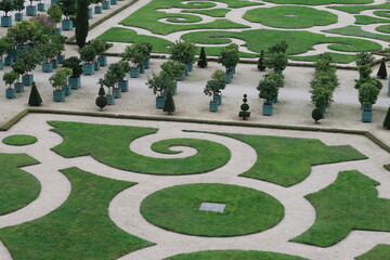 Parterre and rows of shrubs in containers in a formal garden