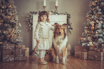 Hübsches kleines Mädchen mit Locken steht mit ihrem rough Collie sable vor dem Weihnachtsbaum zu...