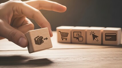 Hand placing a shopping cart icon block on wooden table with other icons