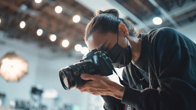 Photographer wearing a mask and holding a dslr camera in a studio setting