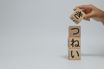 Hand stacking wooden blocks with Japanese hiragana letters