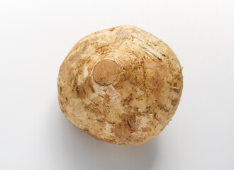 A whole Bengkuang (Jicama), showcasing the rough, earthy brown skin. This vegetable is often enjoyed raw for its sweet, watery crunch in salads and fruit preparations.