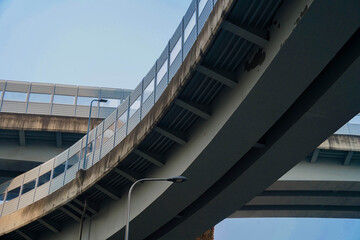 Fragment of a new road junction, bottom view. Overpasses on concrete supports. High-speed movement of vehicles in the city. Construction of express roads. Chengdu Second Ring Road.