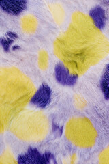 Colorful spotted fur texture in yellow, purple, and lavender shades  