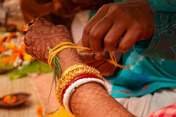 Bengali Hindu Wedding Ritual of Tying Sacred Yellow Thread on Bride&rsquo;s Hand