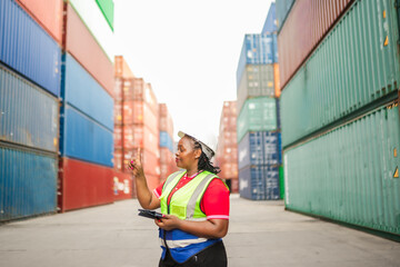 A transportation worker wearing safety equipment interacts with a tablet, pointing upward as if touching a digital interface. The image highlights innovation in logistics and warehouse automation.