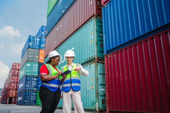 Field supervisors collaborate on freight operations, checking digital reports and confirming project updates to maintain accuracy in the logistics workflow. - Powered by Adobe