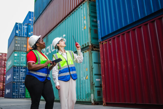 Female staff discuss cargo operations while confirming shipment tracking data and ensuring smooth coordination across all logistics processes at the depot.