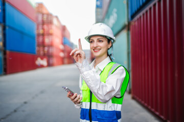 Finger focused, woman in a safety vest and helmet gestures as if touching a virtual interface in a shipping yard. Highlights digital logistics, warehouse innovation, and smart transportation systems.