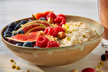 Porridge mit frischen Fruechten, Müsli mit Beeren, Himbeeren, Feigen, Müslischale, isoliert,