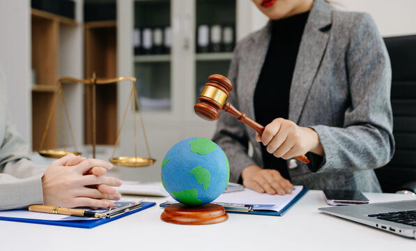 A lawyer presenting a green house model and earth globe with a gavel showing environmental law eco policy sustainability justice