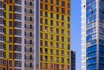 Fototapeta premium Cityscape on a summer day, modern buildings and houses against the blue sky 