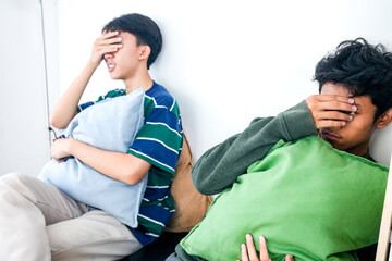 Two Scared Asian Teenagers Watching Horror Movie At Home