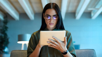 Modern woman using tablet for communication or entertainment in stylish contemporary space indoors