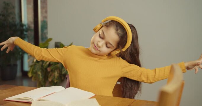 happy white girl dancing during study break with headphones