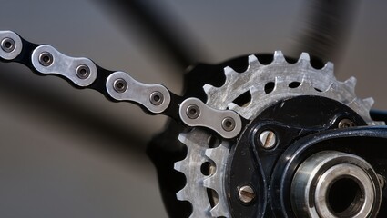 Close-up of a bicycle chain engaged with a metal sprocket, showing detailed links, rivets, and teeth, highlighting mechanical precision, reliability, and drivetrain function