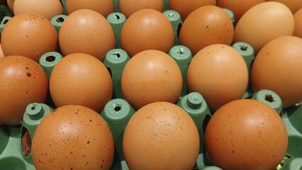 Close-up of fresh brown chicken eggs arranged in a carton, ready for cooking or baking