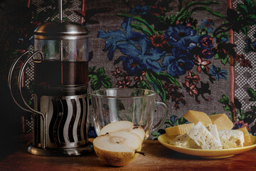 A composition of pears and pieces of delicious cheese with an oriental cup and teapot