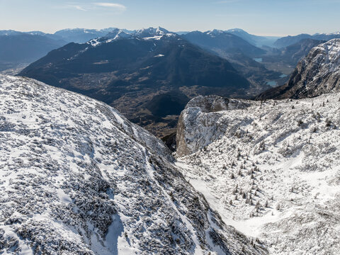 Snowy mountain landscape with a valley and distant mountains under a blue sky. Paganella, Roda refuge,Trentino, Italy