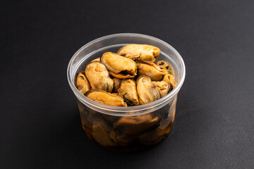 Pickled Mussels in Plastic Container on Dark Background