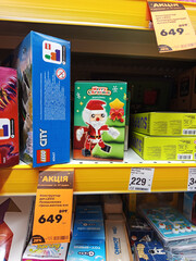 Naklejka premium Zvyagel, Ukraine - December 02, 2025: LEGO Christmas-themed building set featuring a Santa Claus figure on store shelf, showcasing festive toys and holiday spirit in vibrant packaging