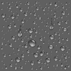A collection of clear, realistic water droplets and condensation on a smooth dark grey surface.