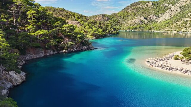 Stunning blue waters and peaceful beaches of Oludeniz in Turkey during sunny afternoon. Flying over blue lagoon in Oludeniz. Best travel destinations in Turkey, aerial shot