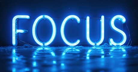 Fototapeta premium Bright neon sign spells FOCUS. Blue light reflects on dark surface. Minimalist aesthetic, simple message, impactful visual.