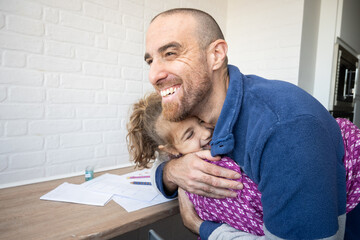 Father hugging his daughter after finishing school homework
