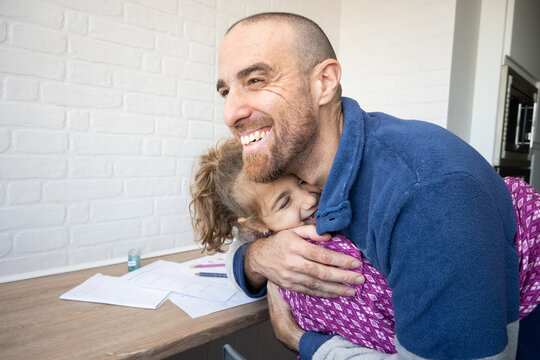 Father hugging his daughter after finishing school homework
