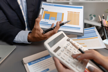 Business professionals reviewing financial charts and performance reports during a meeting, highlighting strategic planning, budget analysis, and teamwork in a modern corporate environment.