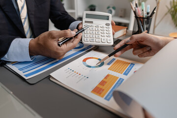 Business professionals reviewing financial charts and performance reports during a meeting, highlighting strategic planning, budget analysis, and teamwork in a modern corporate environment.