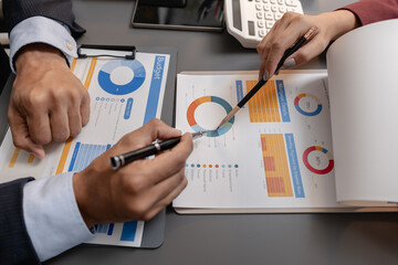 Business professionals reviewing financial charts and performance reports during a meeting, highlighting strategic planning, budget analysis, and teamwork in a modern corporate environment.