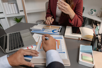 Business professionals reviewing financial charts and performance reports during a meeting, highlighting strategic planning, budget analysis, and teamwork in a modern corporate environment.